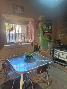 a table in a room with a green monster on the wall at Hostal Rústico Las Pircas in Alcoguaz