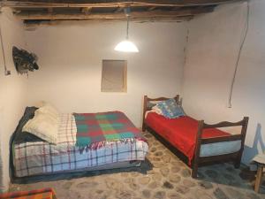 a bedroom with a bed and a chair in it at Hostal Rústico Las Pircas in Alcoguaz