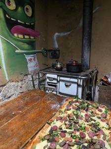 a pizza sitting on top of a table next to a stove at Hostal Rústico Las Pircas in Alcoguaz +14 photos