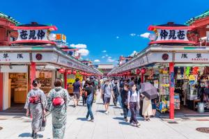 a crowd of people walking through a street with shops at Super Hotel Asakusa in Tokyo