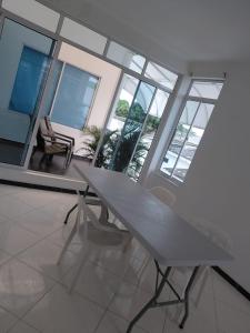 a white table and chairs in a room with windows at Hotel Los Potrillos in Aguazul