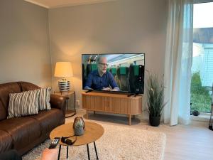a living room with a large flat screen tv at Cozy Home in Sortland in Sortland