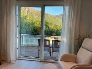 a living room with a sliding glass door to a balcony at Cozy Home in Sortland in Sortland