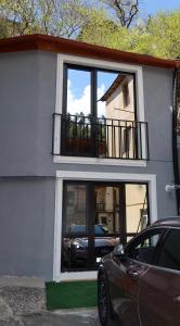 a car parked in front of a house with a balcony at The Fireplace ROOM in Borjomi