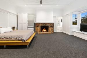 a bedroom with a bed and a fireplace at Kirinaran Manor Pool & Bar Room in Frankston South +17 photos