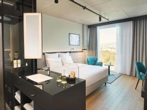 a hotel room with a bed and a desk and a room at Pullman Zagreb in Zagreb +57 photos