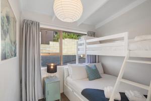 a bedroom with a bunk bed and a bunk bed at Tideview Cottage - Incredible Views - Tairua in Tairua +20 photos