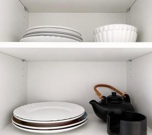 a shelf with plates and a teapot and bowls at Fribourg Home in Fribourg +1 photo