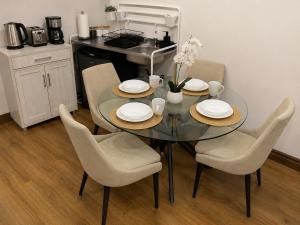 a dining room table with four chairs and a kitchen at Azure Glow Studio in Brossard