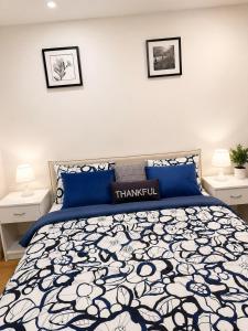 a bedroom with a blue and white bed with two lamps at Azure Glow Studio in Brossard