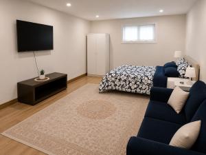 a living room with a blue couch and a bed at Azure Glow Studio in Brossard