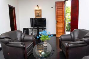 a living room with two leather chairs and a table at Hidden Heaven Grove-Kandy in Kandy