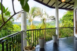 a balcony with a view of the jungle at Hidden Heaven Grove-Kandy in Kandy