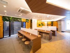 a dining room with tables and chairs in a building at Super Hotel Totsuka Eki Higashiguchi in Yokohama