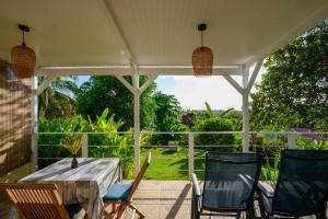 a table and chairs on a porch with a view at Combava à Marie Galante in Grand-Bourg