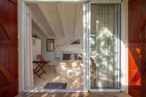 a bedroom with a bed and a sliding glass door at Combava à Marie Galante in Grand-Bourg +6 photos
