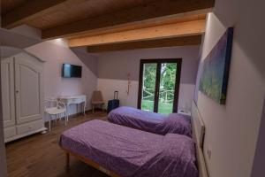 a room with two beds and a desk and a window at Il Moro in Tolentino