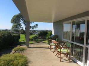 eine Terrasse mit Stühlen und einem Tisch auf einem Haus in der Unterkunft Atalaya in Waihi Beach