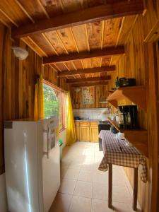 a kitchen with a white refrigerator and wooden walls at Rincón Uruguayo in Monteverde Costa Rica
