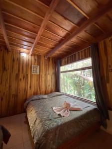 a bedroom with a bed with a pink bow on it at Rincón Uruguayo in Monteverde Costa Rica