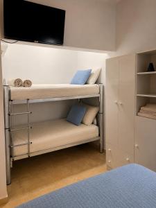 a bedroom with bunk beds with a flat screen tv on the wall at Dunas y Cielo in Tinogasta