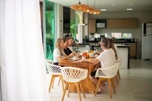 a group of women sitting at a table in a kitchen at Casa Estrela do Mar in Maragogi