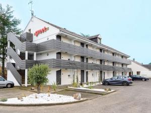 a large white building with a parking lot at greet Hotel Chatellerault in Châtellerault