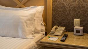 a hotel room with a bed and a phone on a table at Holiday Inn Queretaro Centro Historico by IHG in Querétaro +161 photos