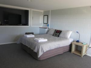 a bedroom with a bed with two towels on it at Atalaya in Waihi Beach