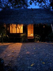 a small hut with a thatched roof at night at Nawala Eco-hostel in Termales - agua caliente - nuqui +3 photos