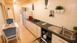 a kitchen with a sink and a counter with a table at Private Vineyard House in Banjol +39 photos