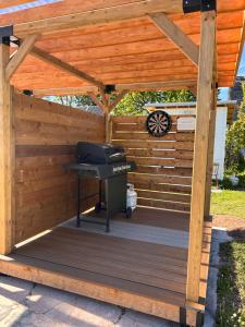 a wooden pergola with a grill on a deck at Garden View near Confederation Bridge and Beaches in Borden-Carleton