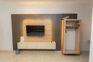 a living room with a tv on a wall at Heyho Homestay Maluk in Maluk