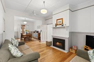 a living room with a couch and a fireplace at Maison Cottage in Queenscliff