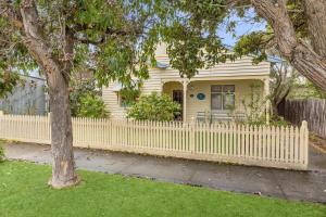 a white picket fence in front of a house at Maison Cottage in Queenscliff