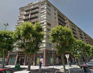 un edificio alto con árboles delante de él en Pensión Amara, en San Sebastián