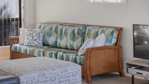 a living room with a couch and a television at The Escape in Merimbula