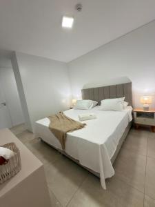 a bedroom with a large bed with white sheets and pillows at Feel Premiun 2401 in Asunción