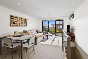 a living room with a table and a couch at Marley s Place in Queenscliff