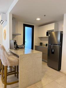 a kitchen with a refrigerator and a table with chairs at Feel Premiun 2401 in Asunción