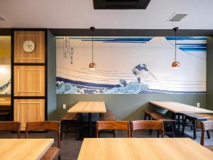 a restaurant with tables and a large painting on the wall at Super Hotel Shinagawa Shinbanba in Tokyo