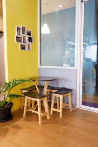 two tables and two chairs in a room with a window at Sleep cafe hidee247 in Pratunam