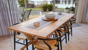 a wooden table with chairs and a bowl on it at PiPis on Collins in Merimbula