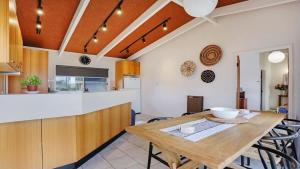 a kitchen and dining room with a wooden table at PiPis on Collins in Merimbula