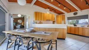 a large kitchen with a wooden table and chairs at PiPis on Collins in Merimbula