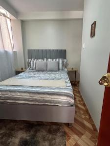 a bedroom with a bed with a gray headboard at Wiracocha Apartments #2 in Pisac +9 photos