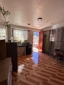 a room with a kitchen with a wooden floor at Wiracocha Apartments #2 in Pisac