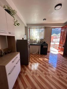 a kitchen with wooden floors and a kitchen with a refrigerator at Wiracocha Apartments #2 in Pisac