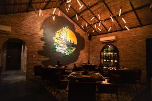 a dining room with a large painting on the wall at The Local Time Village in Siem Reap +82 photos