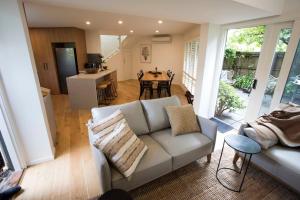 a living room with a couch and a kitchen with a table at Monrepos in Point Lonsdale +8 photos